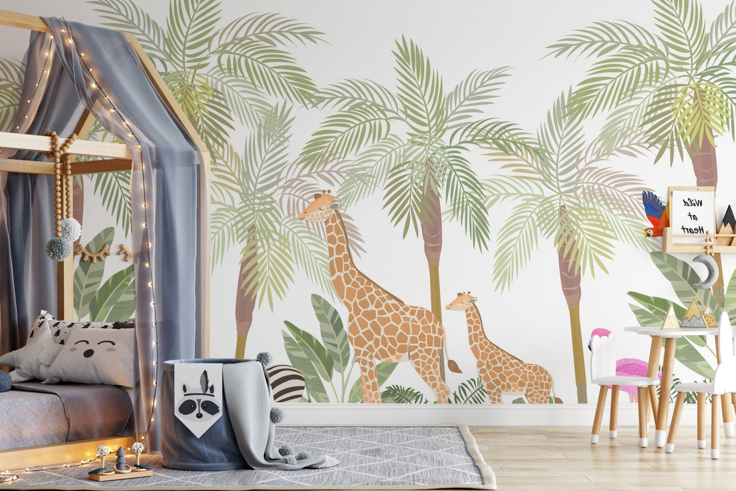 Toddler bed with a house frame next to a large giraffe adventure wall mural.