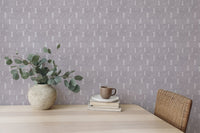 Textured grey snowflakes wall mural with white leaf patterns behind a vase on a desk.