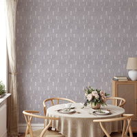 Grey snowflake wall mural behind a round dining table and light wood chairs.