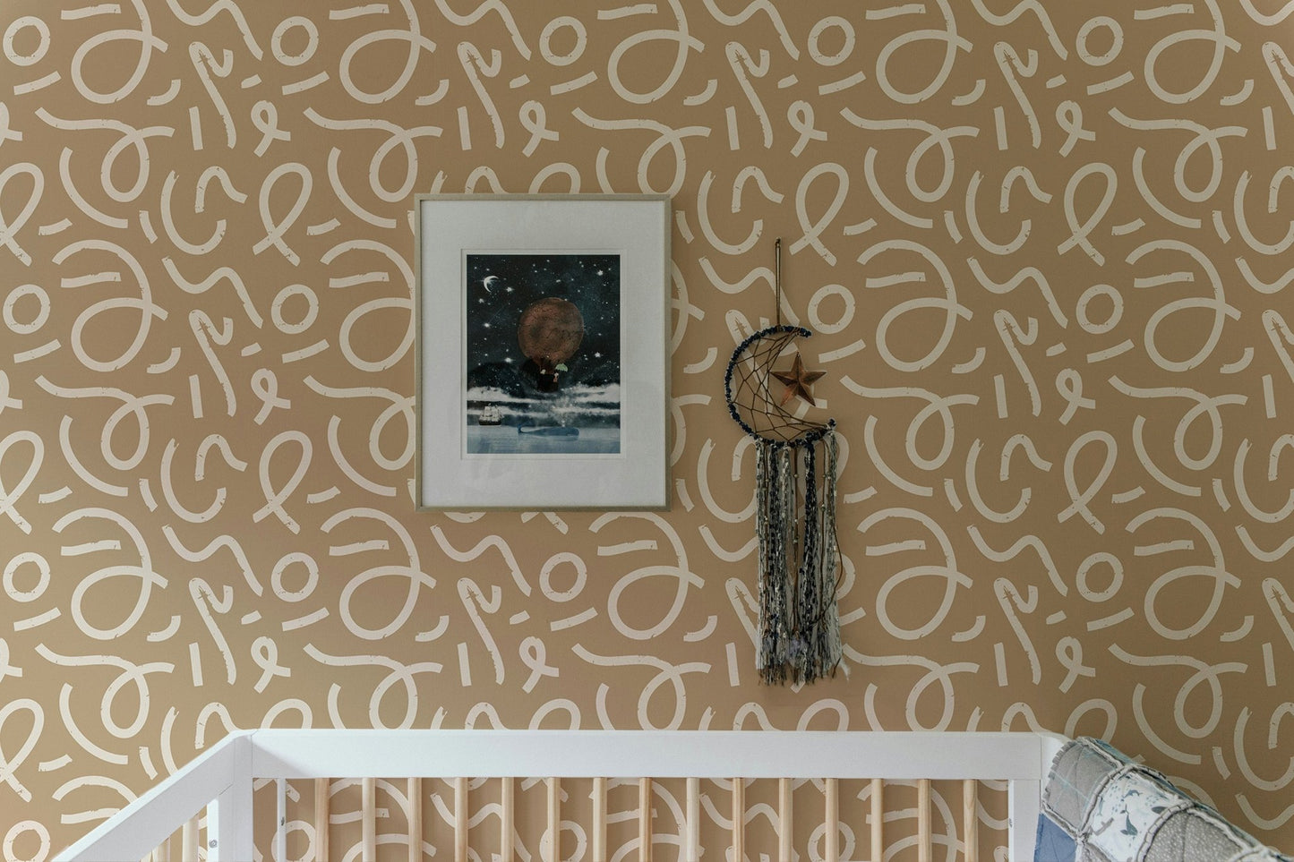 Minimalist brush stroke wallpaper behind a wooden crib in a nursery