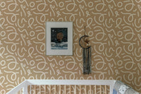 Minimalist brush stroke wallpaper behind a wooden crib in a nursery