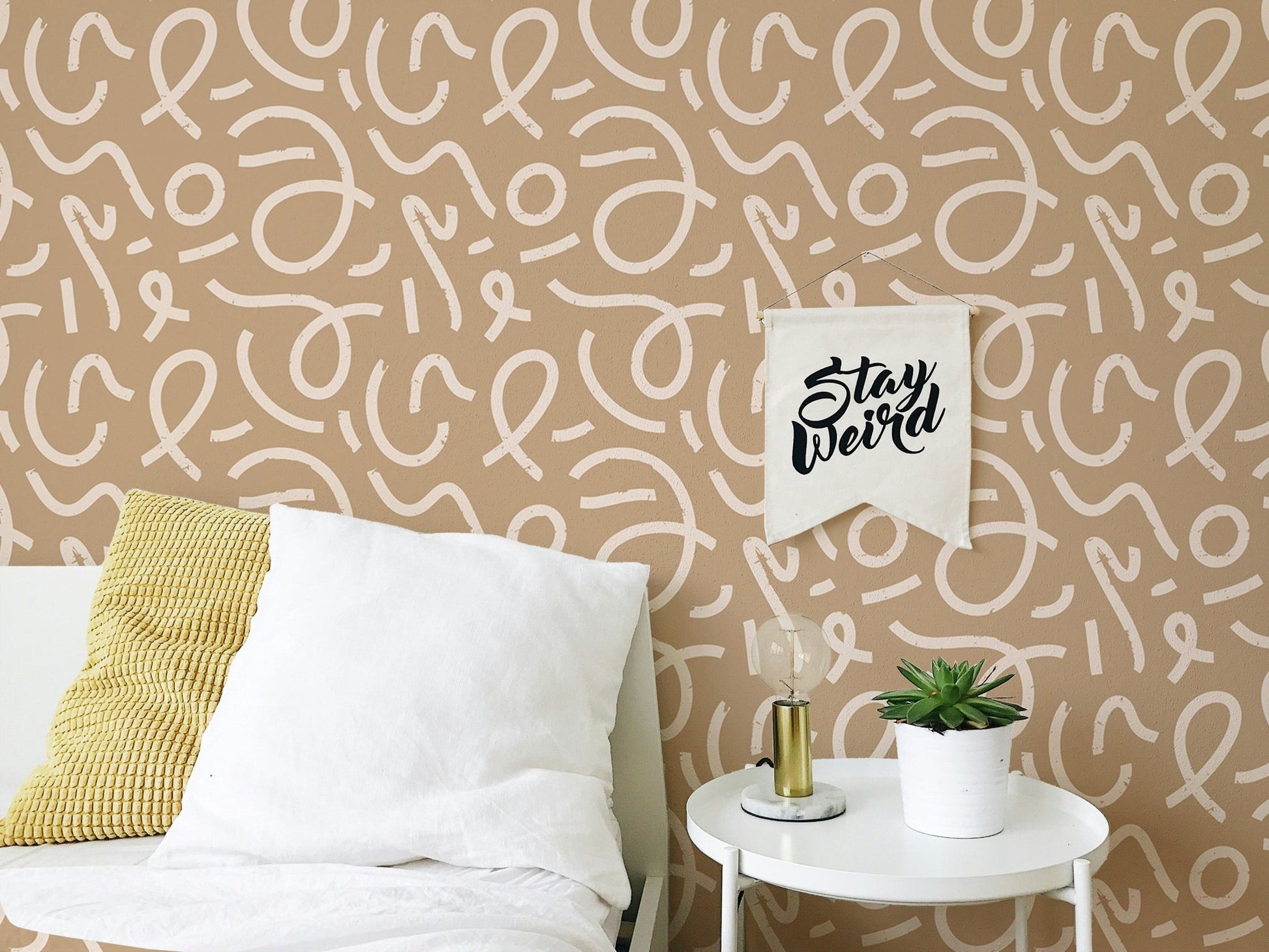 Minimalist line art wallpaper behind a bed with grey and white bedding