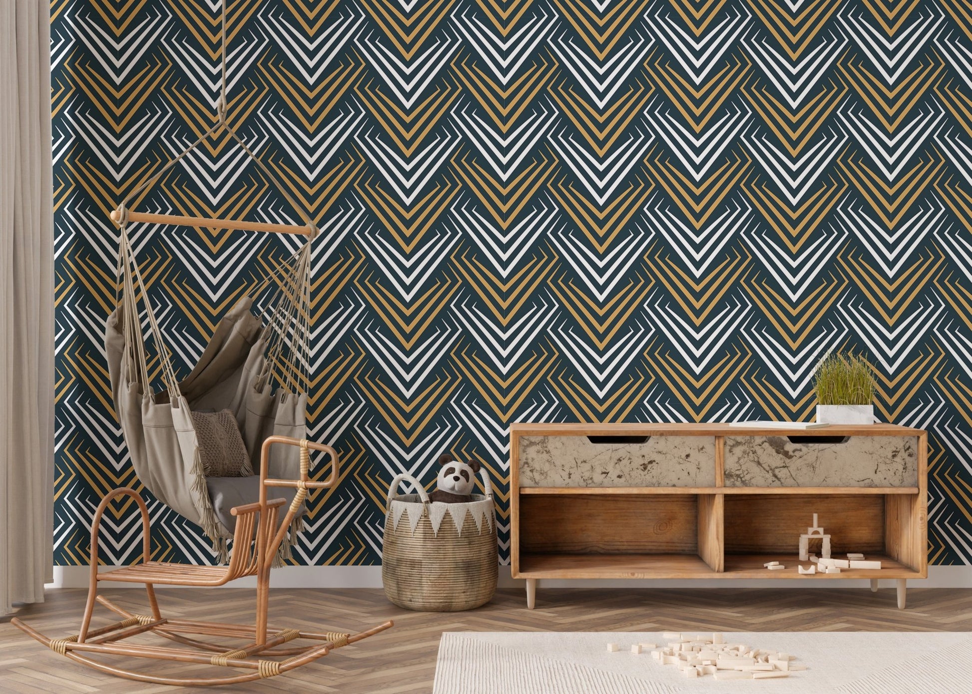 Art deco wall mural in a nursery room with a wooden sideboard and wicker chair.